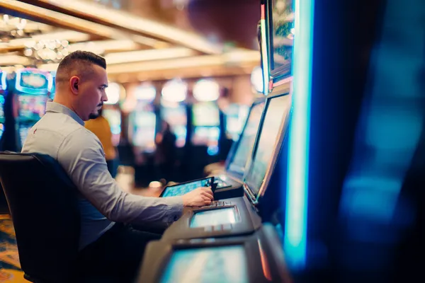 A young woman relaxing with her phone while dynamic casino elements float around her, illustrating the smooth mobile experience offered by the 5XGAME app.