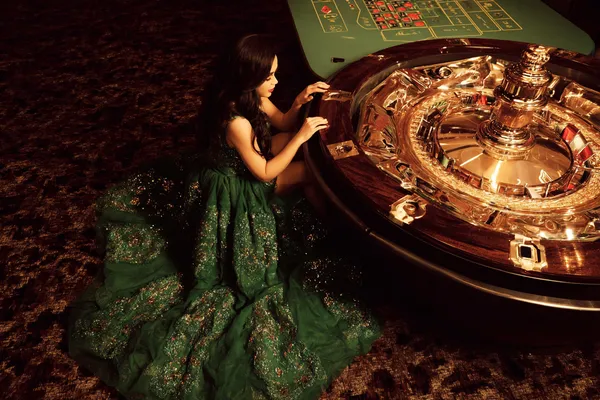 A glamorous woman holding casino chips in a neon-lit environment, representing the premium online casino atmosphere of 5XGAME.